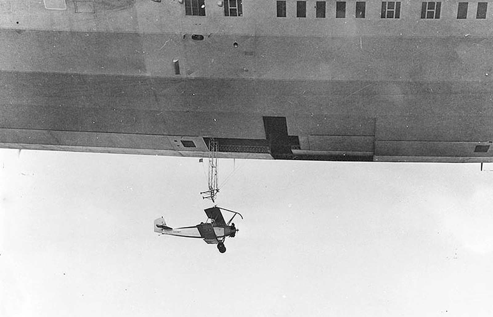 The USS Akron launches a Consolidated N2Y-1 training plane during flight tests near Naval Air Station at Lakehurst, New Jersey, on May 4, 1932.