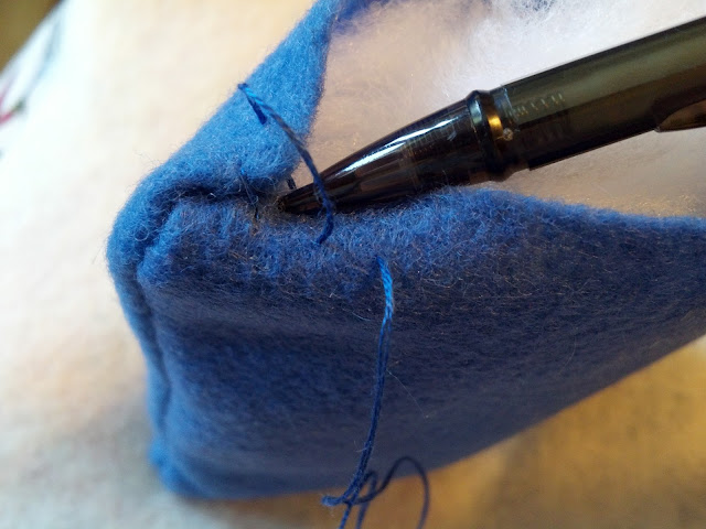 Use a pen or pencil to tuck the fabric edges into the seam