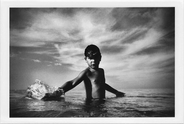 dirty photos - et - a black and white photo of boy playing with water inside the sea