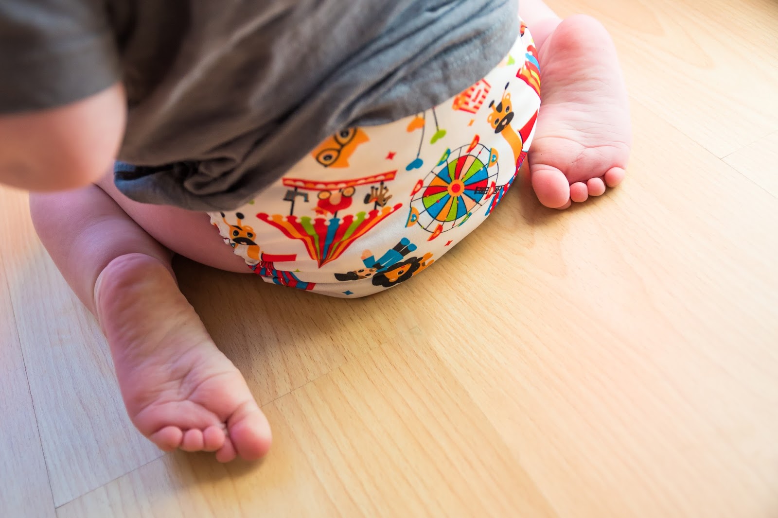 close up of toddler sitting on floor wearing a miosolo cloth nappy