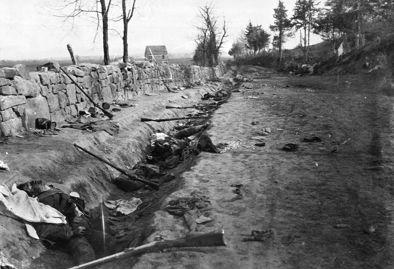 Confederate dead lie among rifles and other gear, behind a stone wall at the foot of Marye's Heights near Fredericksburg, Virginia on May 3, 1863. Union forces penetrated the Confederate lines at this point, during the Second Battle of Fredericksburg.