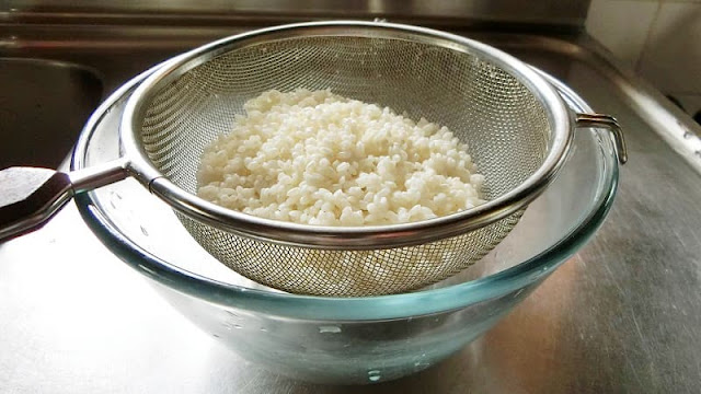 もち米をザルに入れて水けを切る