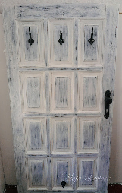 odrestaurowane stare drzwi pomalowane na biało z antracytowymi wieszakami