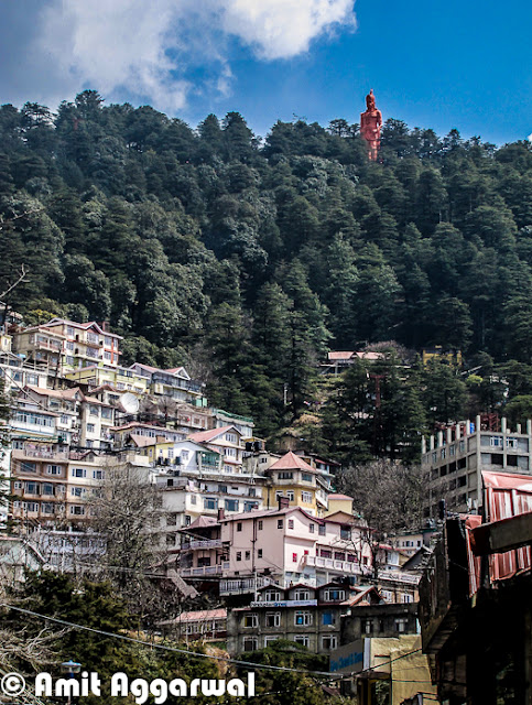 After some wonderful Photo Journeys from Shimla (IIAS, Jakhu & Sankat Mochan), here is another one by Amit Aggarwal. This Photo Journey shares more about Shimla Town and it's beauty.First photograph of this Photo Journy shows a very old Clock on Mall Road. This is places at BSNL office building, which is just in the beginning of Mall Road when we come from Himachal Pradesh University at Summer Hill.Here is a colorful building on other end of Mall Road of Shimla. Although Hotel hoardings are on left side of the building, but it's office of various High Court Advocates.Here is a main Gate of High Court Shimla. High Court Shimla is near to Mall Road and parking area is just next to mall road only.Most of the buildings around Shimla are quite interesting with slanting roofs, which are important in regions which get heavy snowfall and rains.Shimla is extremely dense and day by day it's spreading like other big cities of India. During a short visit to Shimla, every tourist like this city - It's beauty, freshness and weather. But Shimla has nt enough resources for people living there. Water is one of the biggest problem during summers. This sounds weird that hill station faces water-problem in summers, but that's true. Shimla has not big river nearby and the way population is increasing, it's always difficult to meet the requirement even when every year lot of efforts go into bringing water to the town from surrounding riversSince town was not planned to handle this much population, not we can easily see severe traffic jams around roads in Capital City of Himachal. Parking is one of the biggest problem as majority of families have four wheelers now and hardly any space to park. Tourism department has tried to solve parking problem for tourists who visit the town in their own carsColorfulness of houses in Shimla is very attractive and different from other cities. Being a hilly station, it has a big opportunity to do show-off because more number of houses can be seen at one point of time, which is not that possible in plains Here is a photograph of starting of shopping area on Mall Road, which is quite near to office of District Commissioner and Kalibari Temple. The building on left  is BSNL head office of Himachal Pradesh and on right are various showrooms having brands like Reebok, Adidas. There is a shop called 'City Point' near the beginning which is very famous for pastries..Mall road is most popular place in Shimla for Shopping. Apart from popular brands, there are some interesting shops to get woolens, stuff for kids and girls etc.Many offices of Shimla are around Mall Road and others are towards Chhota Shimla and New Shimla region. Here is a photograph showing SP office of Shimla. Most of the office buildings are old and built in British styleShimla Townhall, which is quite popular among Bollywood folks. Most of the bollywood folks who come to Shimla for shooting, choose this building of one or more shots. Movies like Kareeb are almost completely show around this place. This is center of Mall Road and most crowded place around Ridge ground of Shimla A view of beautiful Church on Ridge, Shimla. This photograph is clicked from Mall Road which is just below this Church.A view of World's highest Hanuman Statue at such a high altitude. This photograph is shot from Mall Road and this statue  is higher that these high deodar trees. It's 108 feet high ! To know more about Jakhu Temple and this Hanuman Statue, please check out - http://phototravelings.blogspot.com/2012/04/jakhu-temple-with-worlds-highest.htmlHere is a photograph of Indira Gandhi State Sport Complex which is located in the middle of Mall Road, which is just in front of HPTDC Lift. Indira Gandhi Sports Complex in Shimla is a very famous complex not only in Himachal Pradesh but also in India. It provides all required facilities for organizing events of sports as well as trade. This complex has been organizing so many events for a longer period of time. The venue is liked by sports and other event organizers as they get enjoyments together, one they do their professional work and two they get a chance to see the natural sight of Shimla. IGSS complex provides a very big space which can be utilized as per the requirement of an indoor as well as outdoor event. The complex provides good facility to sit and to enjoy for the people who get there to entertain them.