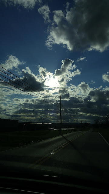 White clouds in dark blue sky road scene