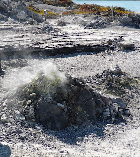 Pile of rocks with yellow suphur cap and excaping steam 