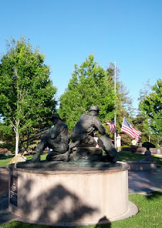 Memorial to fallen veterans, with scouts lowering American flag.