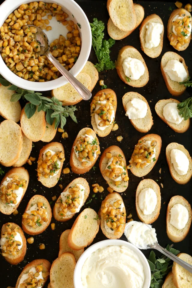 This Whipped Feta and Corn Crostini pairs pan-seared Libby's Whole Kernel Sweet Corn with salty feta cheese and fresh herbs in a delicious finger food appetizer that is perfect for parties! #sponsored #Cansgiving @LibbysTable