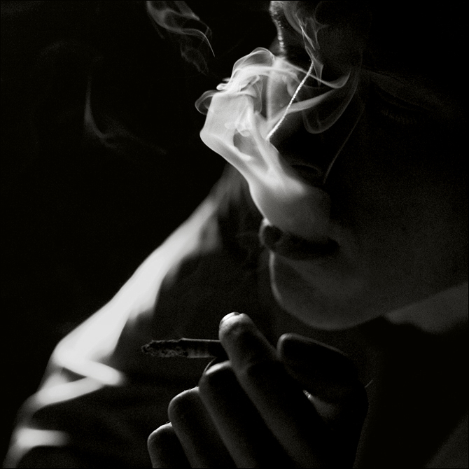 Песня больно курить. Курящий в темноте. Парень курит в темноте. Парень с сигаретой в темноте. Грустный человек с сигаретой.