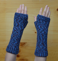 A pair of fingerless mitts with extra length at the wrists extending two thirds of the way up the forearm.  This view is looking down at the back of the hands.