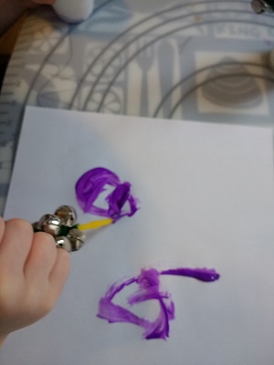 Preschooler painting with bells