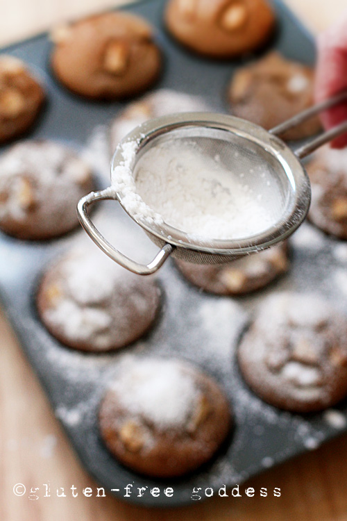 Sifting powdered sugar on gluten-free apple cake muffins