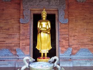 Standing Buddha Statue Carrying Jug In Front Of The Door At Brahmavihara Arama Monastery North Bali