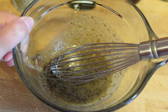 The mustard, honey, thyme, garlic powder, salt, pepper, and oil being whisked together to create the glaze for he chicken. 
