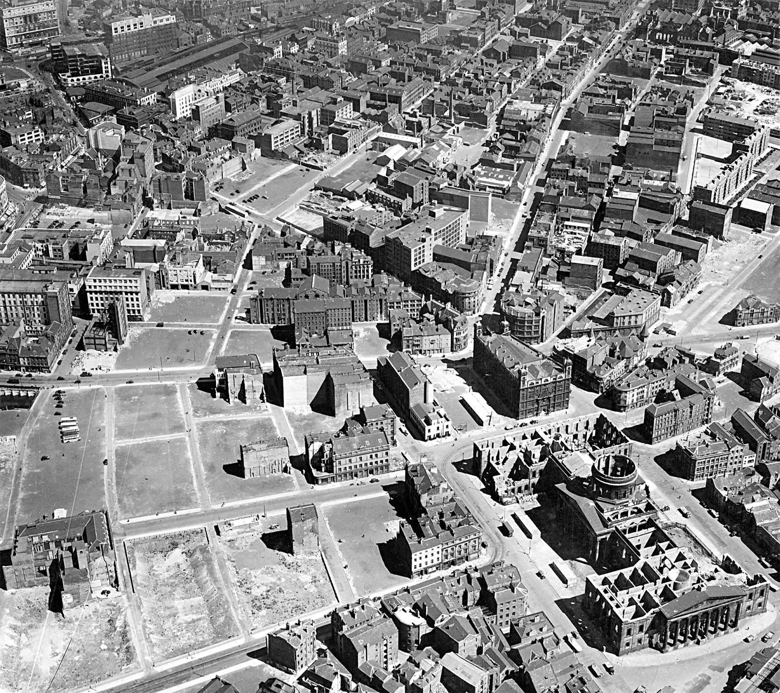 Aerial view of the city centre, showing the clearing of bomb sites.
In the foreground the Customs House, bombed and derelict, can be seen, with the Sailors' Home behind it.
Duke Street and Hanover Street run inland from the Home.