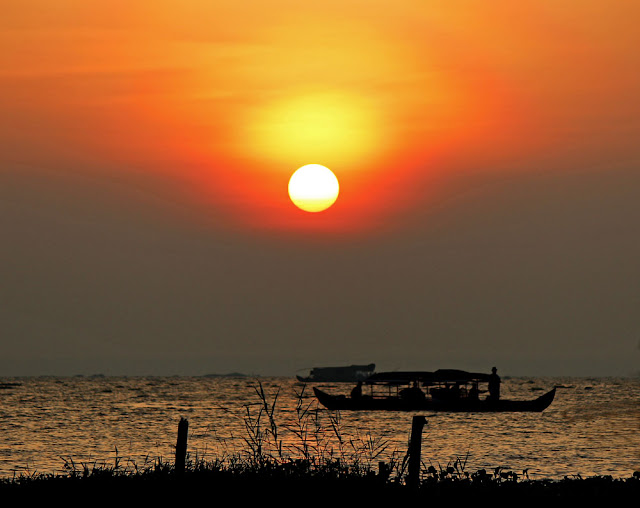sun setting on Lake Vembanad in Kerala, India