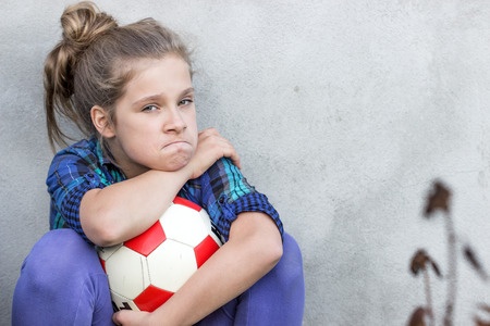 girl sulks with football