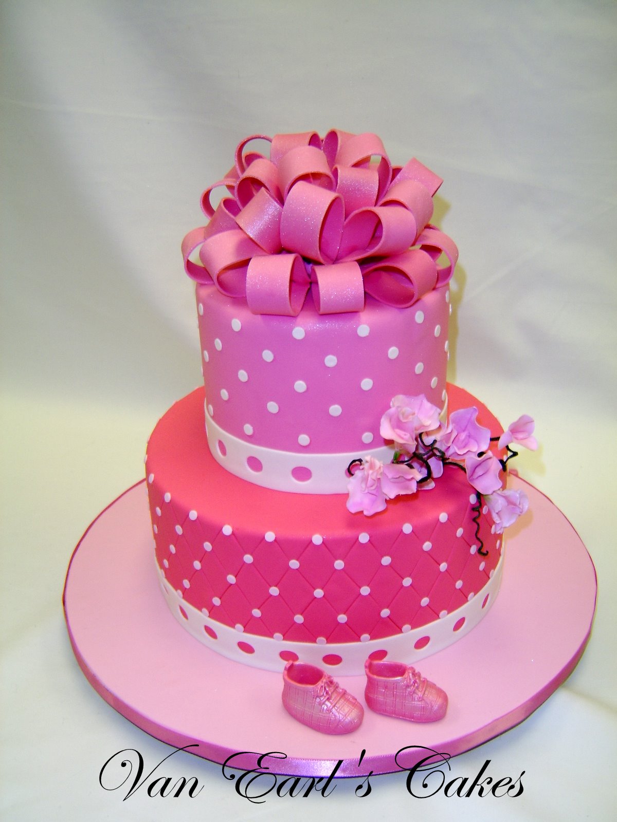 two tier baby shower cake designed in different shades of pink and ...
