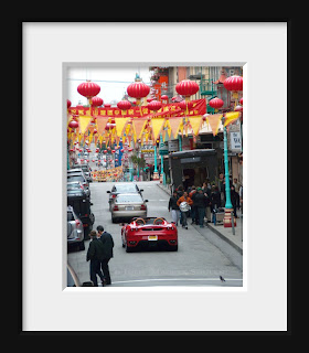 A red hot Ferrari tours through Chinatown in San Francisco.