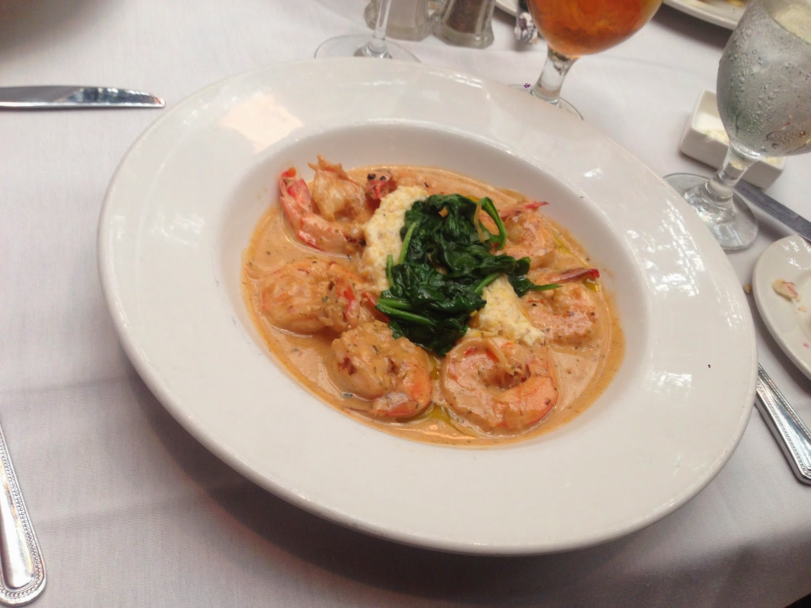 Juban's Shrimp & Grits: Gulf shrimp broiled in New Orleans barbeque butter, with garlic cheese grits,  and spinach primavera