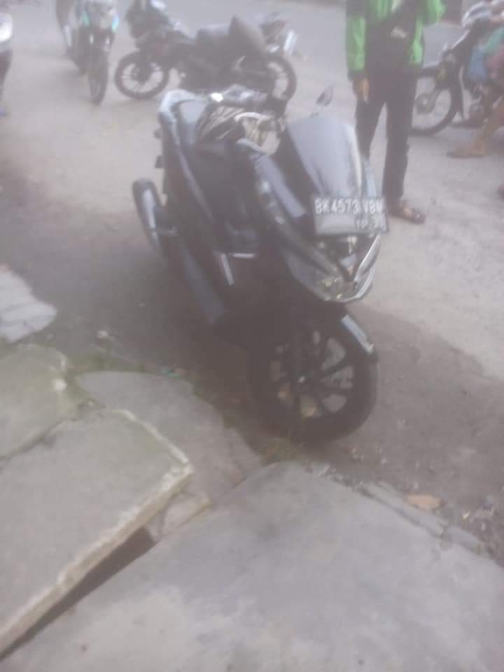 Warga mendirikan sepedamotor milik korban. Warga mendirikan sepedamotor milik korban.