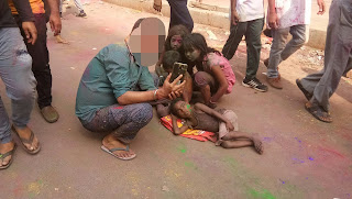 Person taking selfie with poor children giving them the joy of the festival of colours. Showing the contrasting colour od our society 