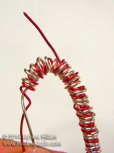 Pull the wire part way out at the top of the hook between the coils so it can be used for creating an eye loop.