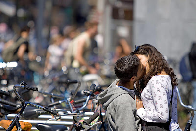 A couple happily snogging Amsterdam style on a bike