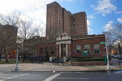 Small red brick Renaissance Revival style Library surrounded by large public housing buildings
