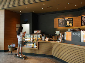 young woman on skateboard at a Starbucks counter
