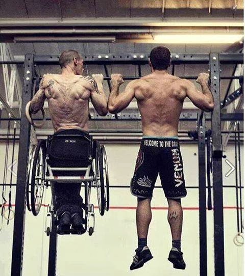 Two men viewed from behind doing pull-ups, man on the left is in a wheelchair