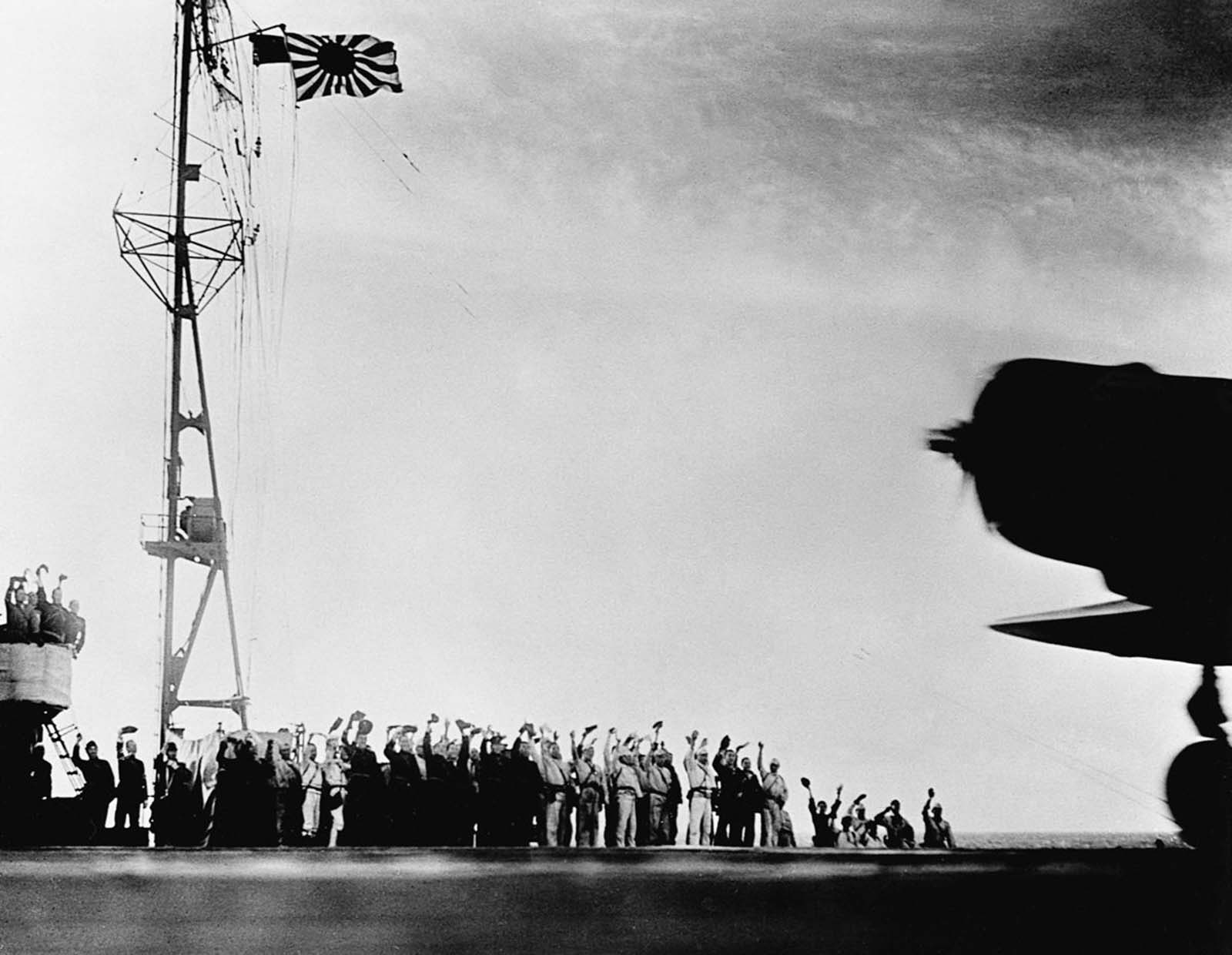 Sailors cheer as planes take off from a carrier to attack Pearl Harbor.