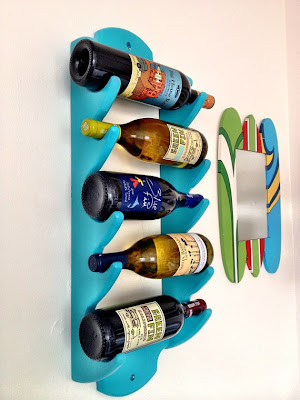 wall-mounted wine rack, aqua blue, holding 5 bottles
