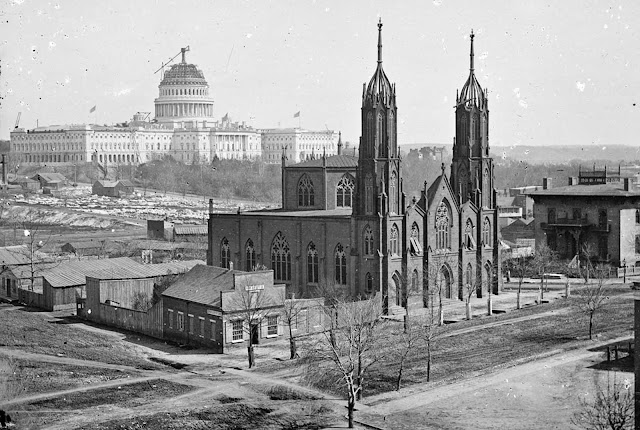 A view of Washington, District of Columbia, from the intersection of 3rd and Indiana Avenue, ca. 1863. In the foreground is Trinity Episcopal Church, in the background, the unfinished Capitol building. Construction on the capitol was briefly suspended early in the war, but continued through the later years.
