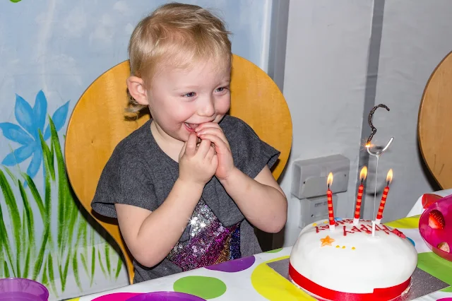 Blowing out the candles on the 3rd birthday cake