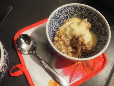apple crumble and custard in a bowl with a spoon