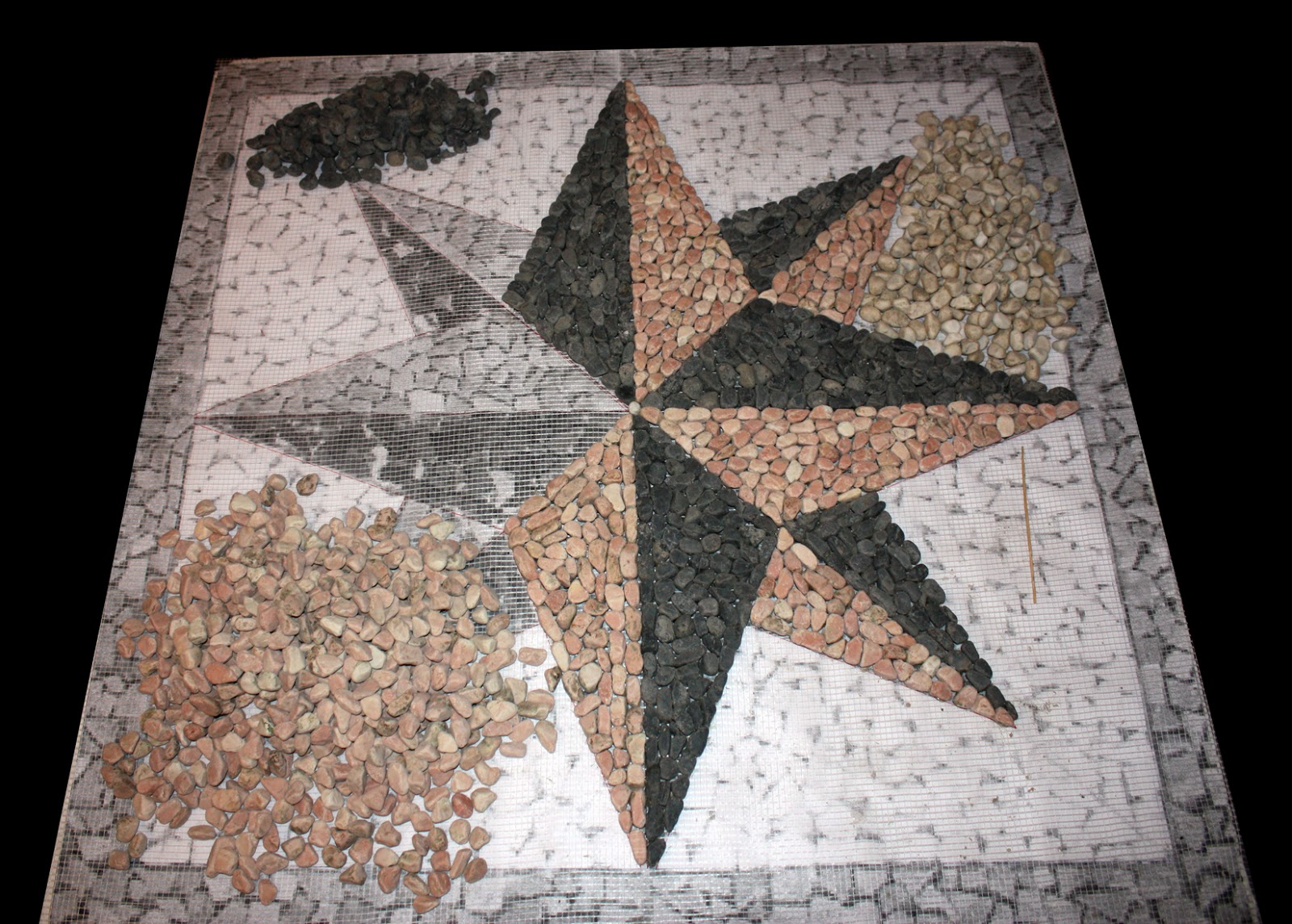 Un pezzo alla volta Rosa dei venti a mosaico, sassi di marmo su rete