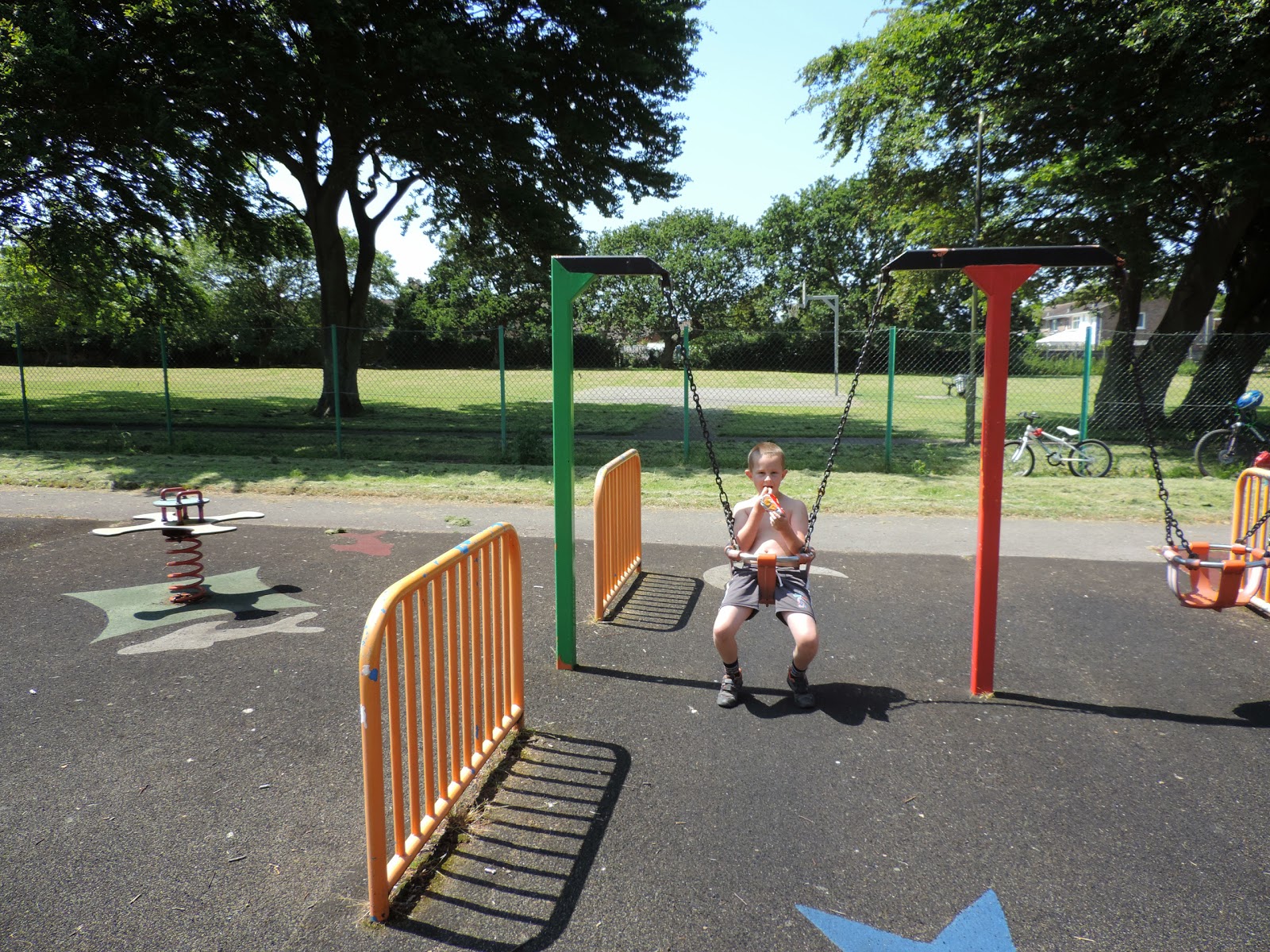boy eating hula hoops in orange bucket swing in park hayling swing park