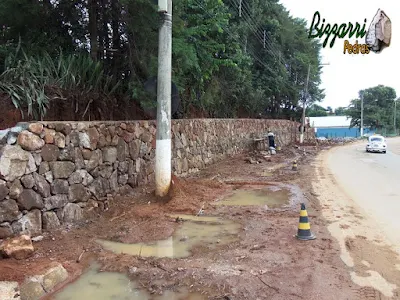 Construção do muro de pedra bruta sendo o tipo de pedra moledo com cores variadas sendo tipo de muro de pedra com junta seca sem massa nas juntas. Muro de pedra na cidade de Joanópolis-SP.