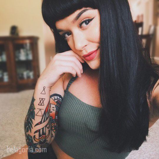 Mujer tatuada con glifos en el antebrazo