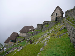 Restored Storage Houses with thatched roofs and Inca Terraces near Entry Gate, Machu Picchu