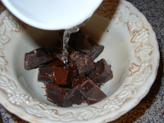 hot water being poured over chocolate that is in a bowl 