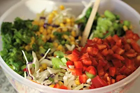 Firecracker Coleslaw by Renee's Kitchen Adventures ready to mix in a white bowl with a wooden spoon