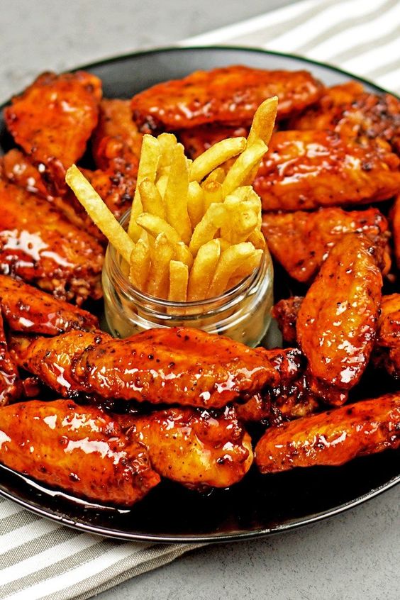 Recipe including course(s): Appetizer; and ingredients: baking powder, black pepper, chicken wings, garlic powder, honey, hot sauce, kosher salt, paprika, rice vinegar, sesame oil