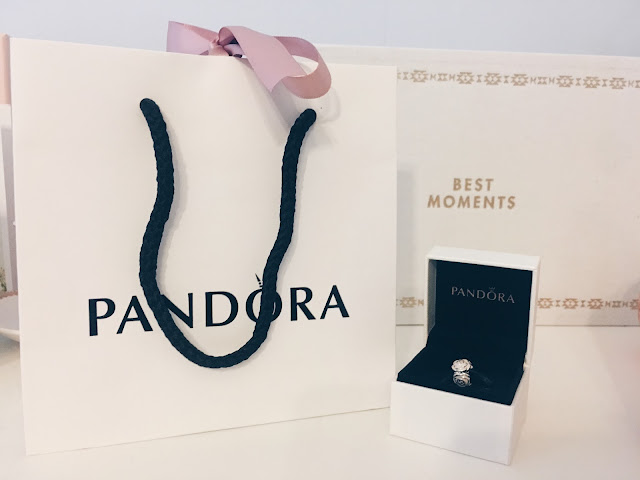 Pandora gift bag next to a pandora box with a charm inside