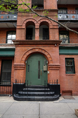 Arched green door with steps on red brick building