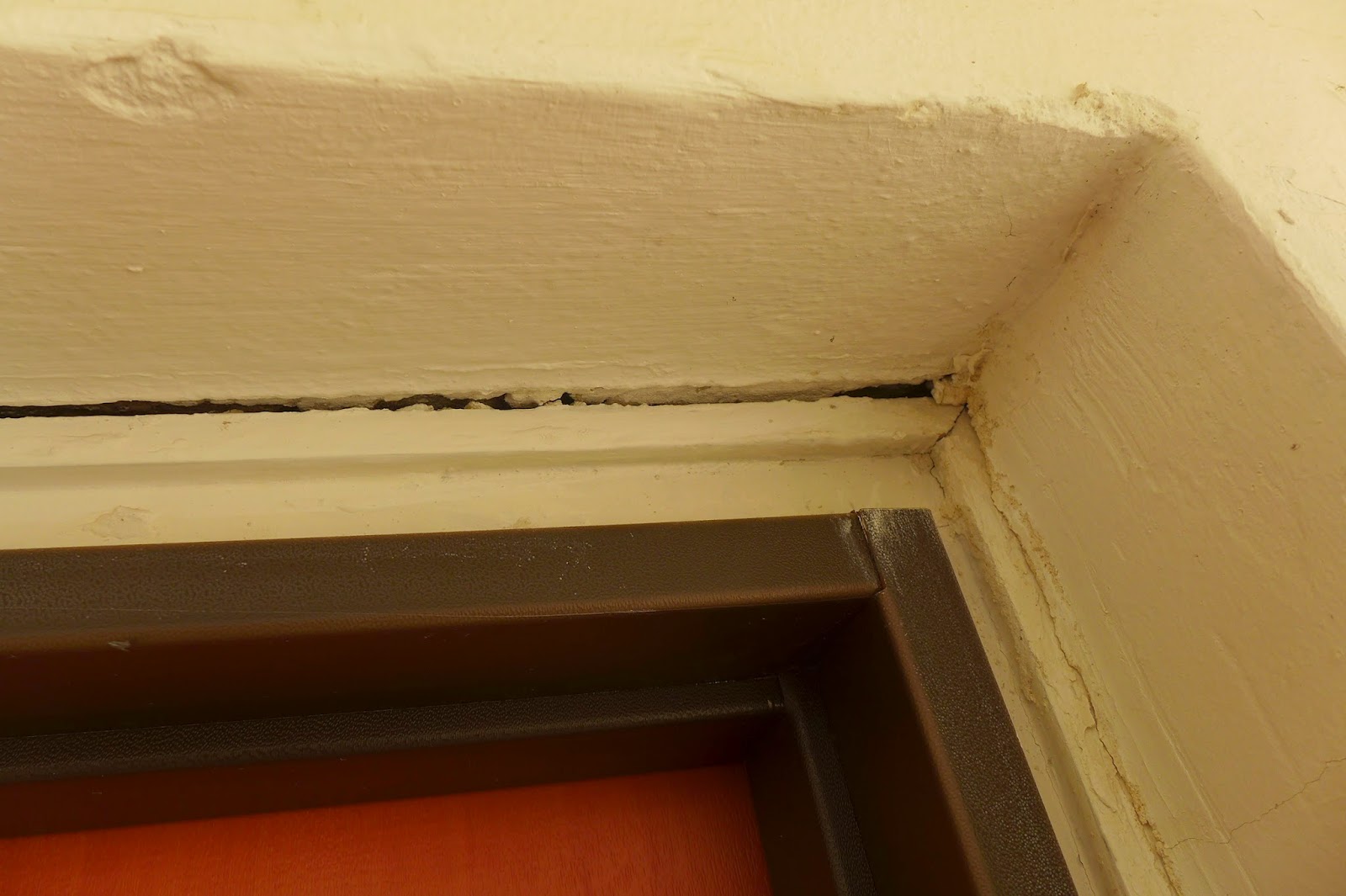 סדק בקיר באזור משקוף דלת הכניסה לדירה עקב בעיטות בלשי משטרת ישראל מרחב דן בדלת