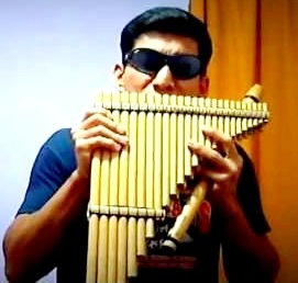 Zampoña Foto de persona con lentes oscuros tocando la zampoña