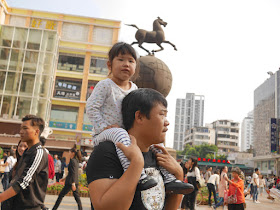 little girl riding on a man's shoulder's