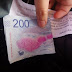 Anciano argentino regala billetes de 200 pesos a desconocidos